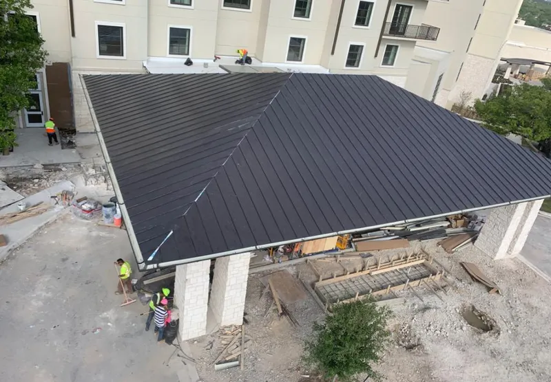 Metal roofing installation team working on a commercial building in Lehigh Acres